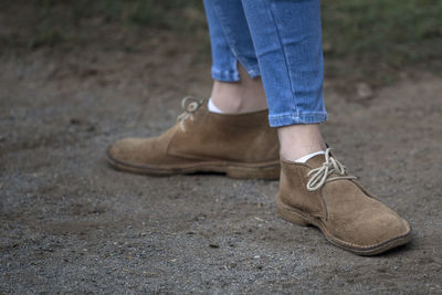 Low section of man wearing shoes standing outdoors