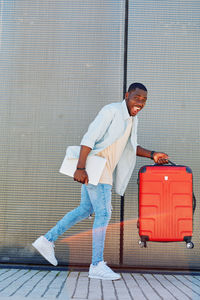 Portrait of young man standing against wall