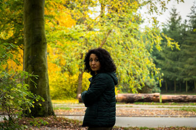 Portrait of serious woman with arms crossed standing at park