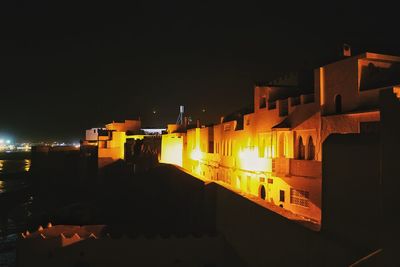 Illuminated city against sky at night