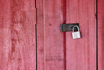 Padlock hanging on red door