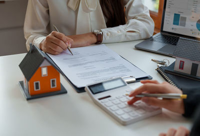 Midsection of businesswoman working on table
