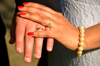 Midsection of couple wearing wedding rings