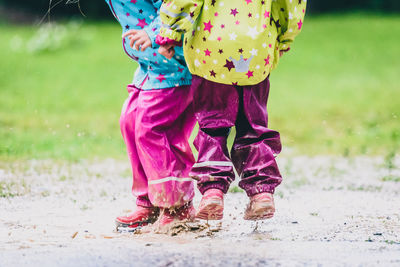 Low section of children playing in puddle