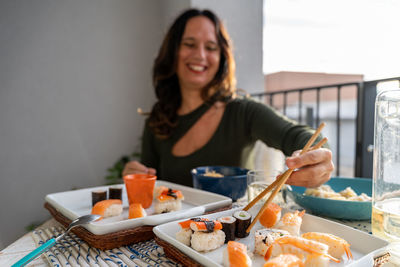 Portrait of young woman having food at home