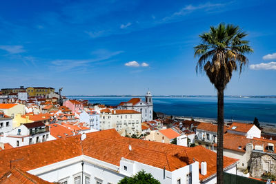 High angle view of town by sea against sky