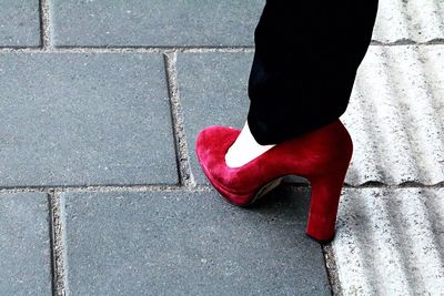 Low section of woman wearing red shoes