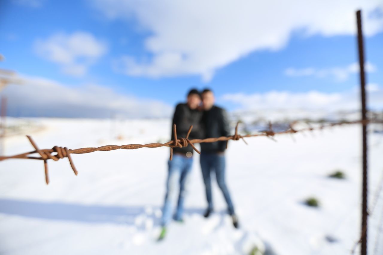 lifestyles, leisure activity, rear view, togetherness, focus on foreground, men, sky, full length, standing, person, bonding, casual clothing, childhood, love, selective focus, boys, fence