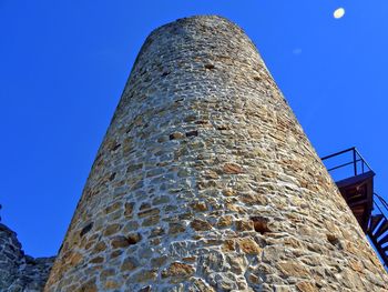 Low angle view of tower against blue sky