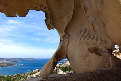 Rock formation in sea against sky