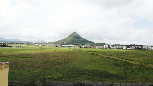 Scenic view of field and mountain against sky