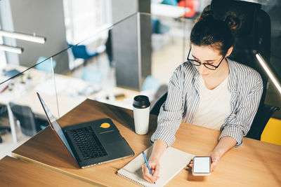 Portrait of young businesswoman working at desk in office