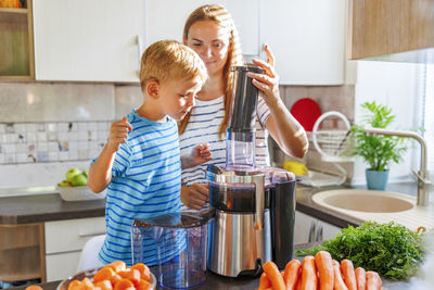 Portrait of siblings playing in kitchen