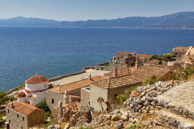 High angle view of buildings by sea against sky