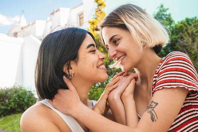 Close-up of smiling lesbian couple romancing outdoors