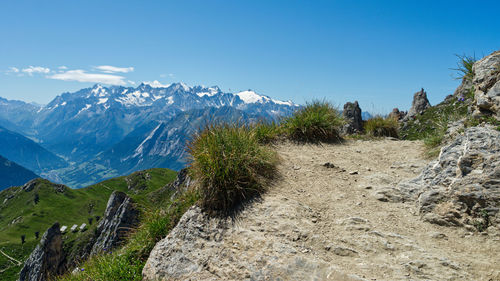 Scenic view of snowcapped mountains against blue sky