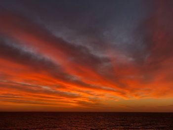 Scenic view of dramatic sky over sea during sunset