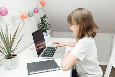 Distance learning at home. a schoolgirl girl does her homework on a laptop or watches a webinar