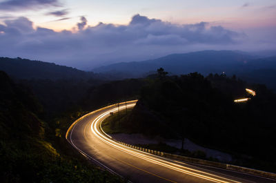 High angle view of light trails on mountain road at night