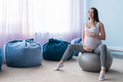 Full length of woman sitting in mirror