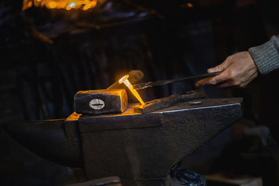 Close-up hot metal nail on an anvil in blacksmith's workshop