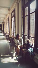 Mother and son sitting by window