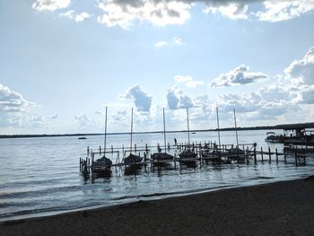 Sailboats moored on sea against sky