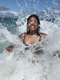 Portrait of a smiling young woman splashing water