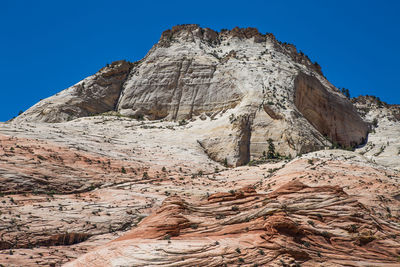 Low angle view of rock formation against clear blue sky