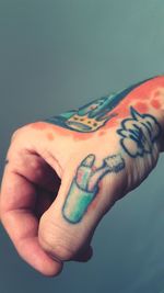Close-up of man hand with tattoo on background