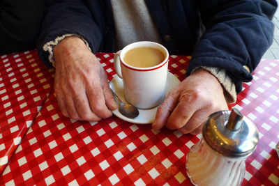 Midsection of man holding coffee cup