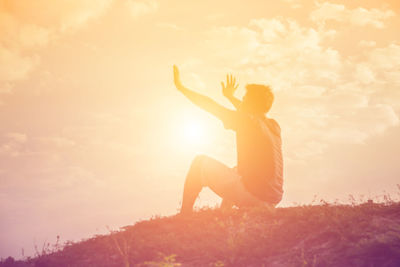 Couple sitting on orange sky during sunset