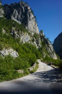 Road by mountain against clear sky