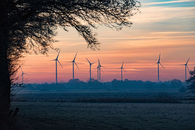 Silhouette of windmills at sunset