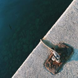 High angle view of rope tied to cleat on pier