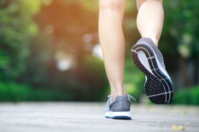 Low section of woman walking on footpath