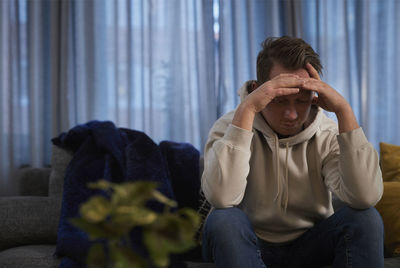 Ill man sitting on sofa