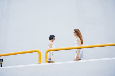 Lesbian couple standing by railing outdoors