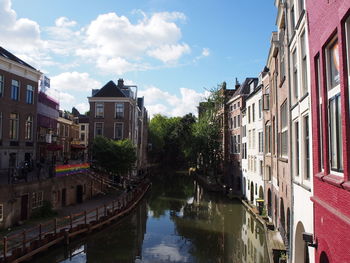 Canal amidst buildings against sky in city