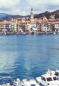 Buildings by sea against sky in town