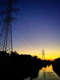 Electricity pylon against sky at sunset