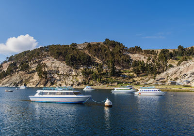 Sailboats moored on sea against sky