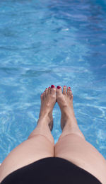 Low section of woman feet in swimming pool