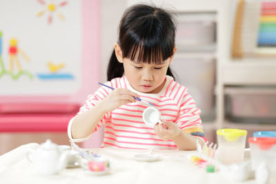 Cute girl playing with toy at home