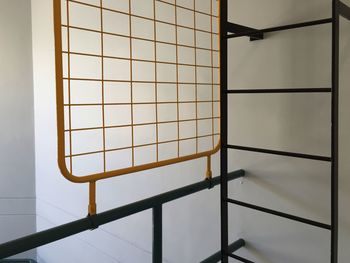 Metallic railing against white wall