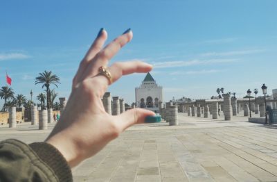 Close-up of hand holding historic building in background