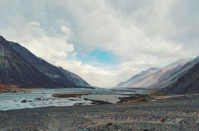 Scenic view of land and mountains against sky