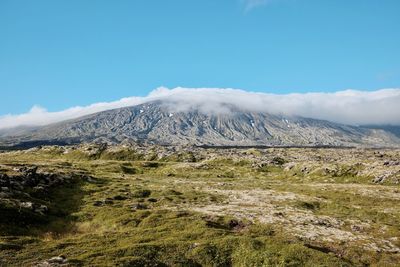 Scenic view of snowcapped mountains against blue sky