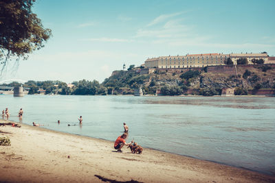 People at beach against sky