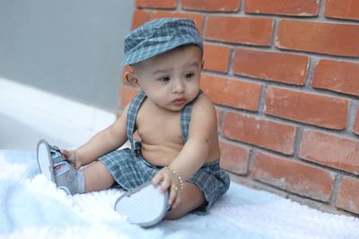 Cute baby girl sitting on wall